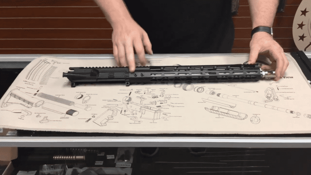 Gunsmith examines rifle assembly on schematics, epitomizing precision in firearm craftsmanship.