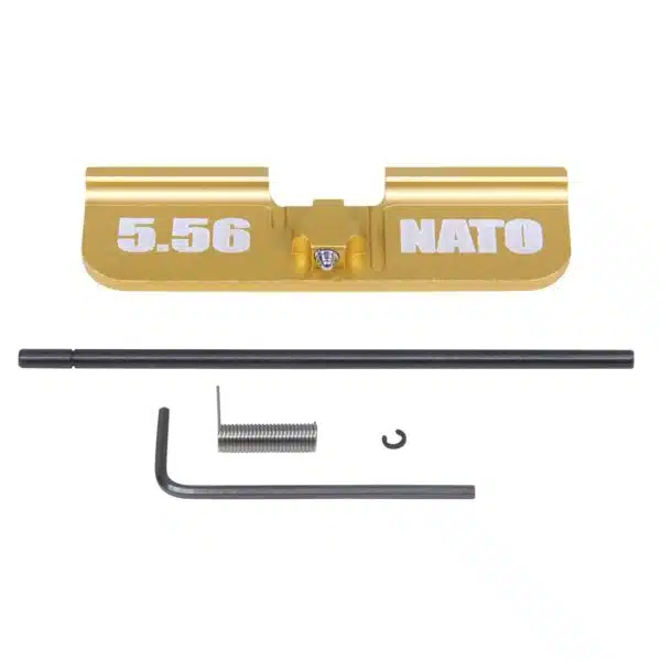 Gold anodized AR-15 dust cover with 5.56 NATO engraving and installation tools on white background.