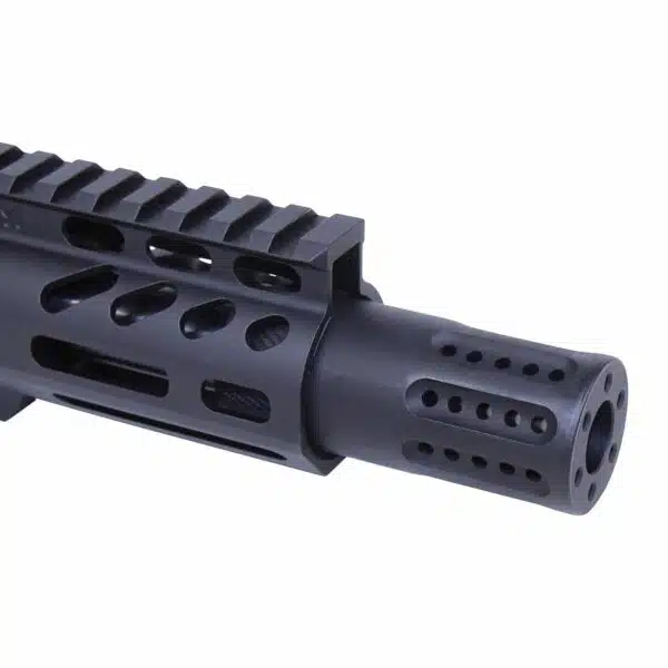 Close-up of matte black firearm muzzle device with machined ports on a tactical rail.