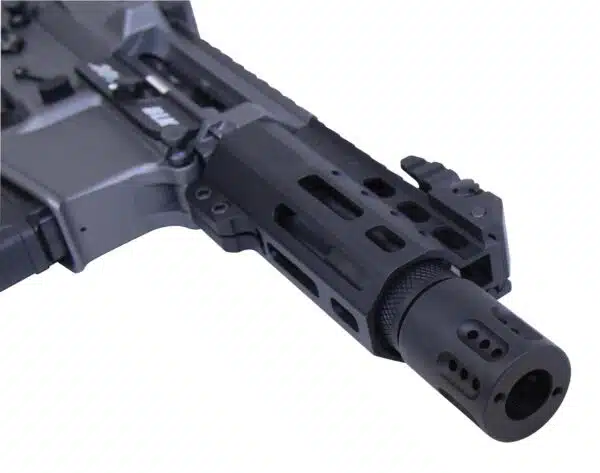 Close-up of tactical rifle barrel with muzzle brake and accessory rail in matte black.