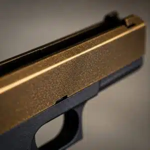 Bronze-finished handgun close-up, highlighting textured slide and matte black frame.
