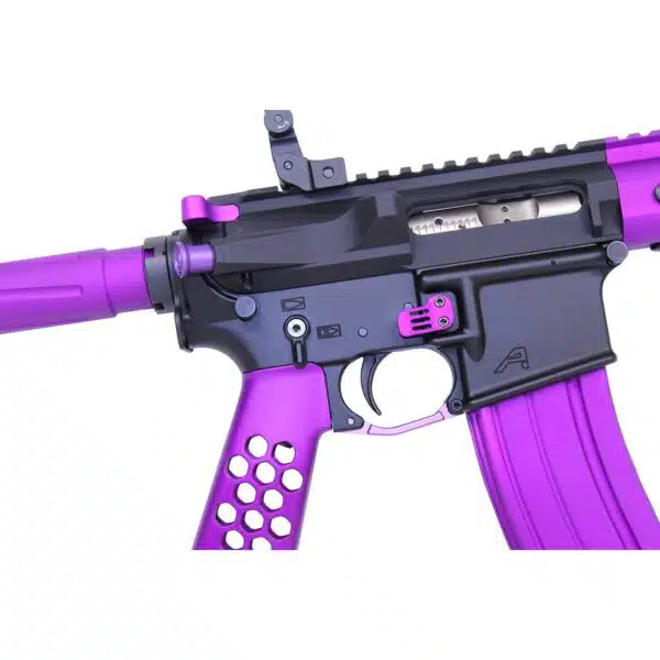 Close-up of AR-15 with pink anodized charging handle and purple details.