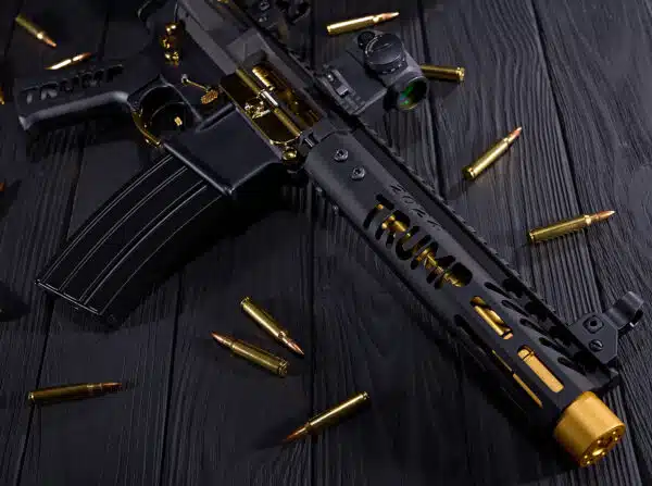 Limited Edition Trump Series AR-style rifle with gold accents on dark wood background.